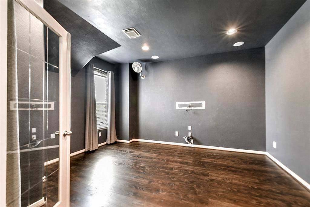 The media room features French doors, matching wood flooring, high ceilings, front yard views, and recessed lighting. Perfect for relaxing or entertaining.