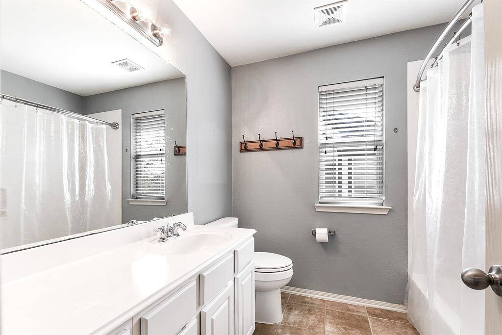 Upstairs offers two full bathrooms. This one features a bathroom window, a large vanity with ample storage and workspace, and a tub-shower combo.