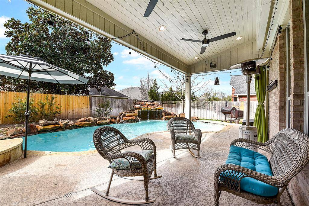 The spacious back patio is designed for comfort and functionality, featuring dual ceiling fans and recessed lighting to keep the space bright and breezy. The entire patio is finished with cool decking, providing a comfortable, non-slip surface—perfect for Texas summers.