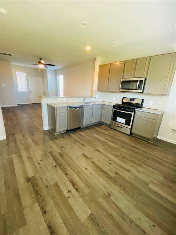 This spacious kitchen has stainless steel appliances and a back door leading to the covered patio.