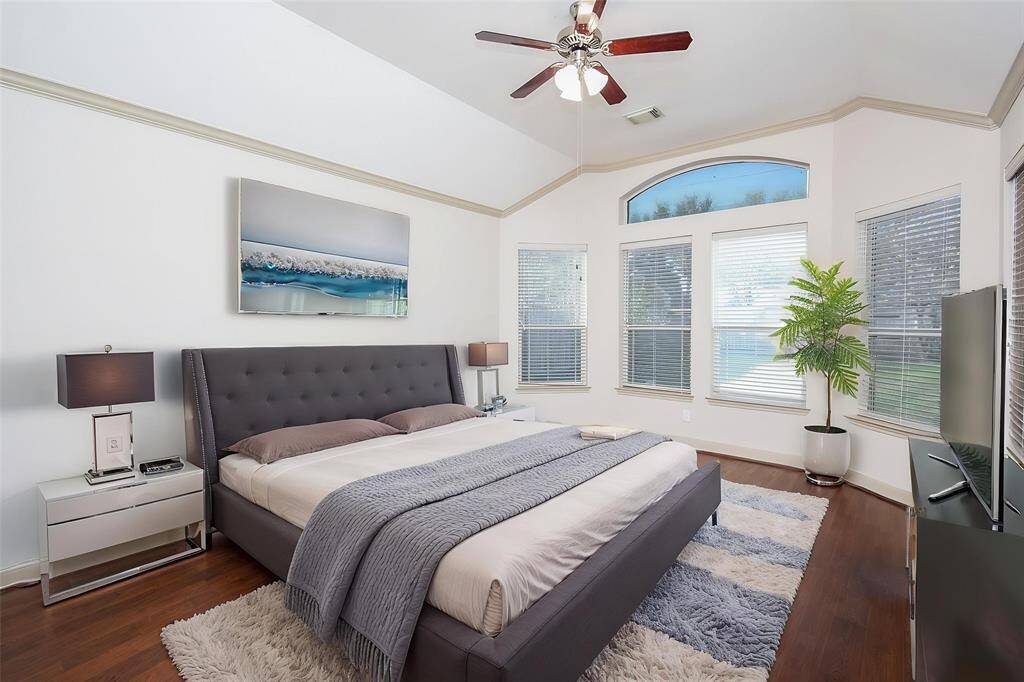 Spacious Primary bedroom features rich hardwood flooring, high ceilings and great view of backyard. Virtually staged.
