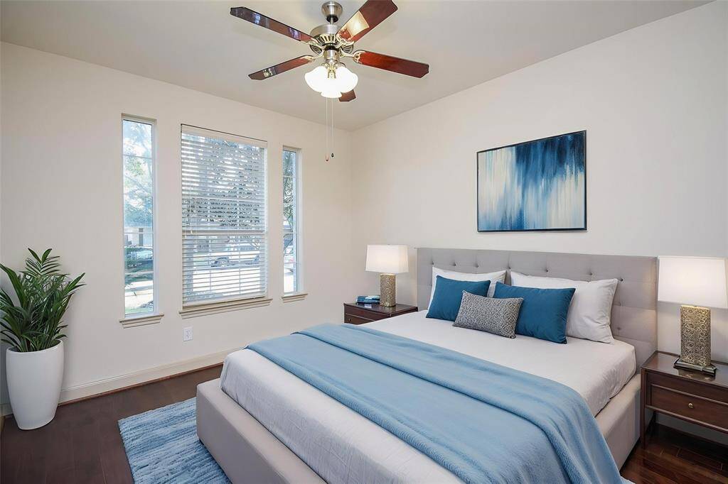 Second downstairs bedroom with hardwood flooring and tall windows. Virtually Staged.