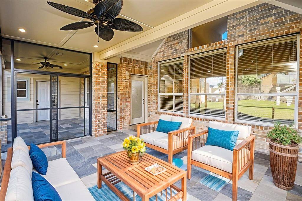 Screened-in patio with a tile floor, ceiling fan, and a view of the backyard making it an inviting outdoor space.