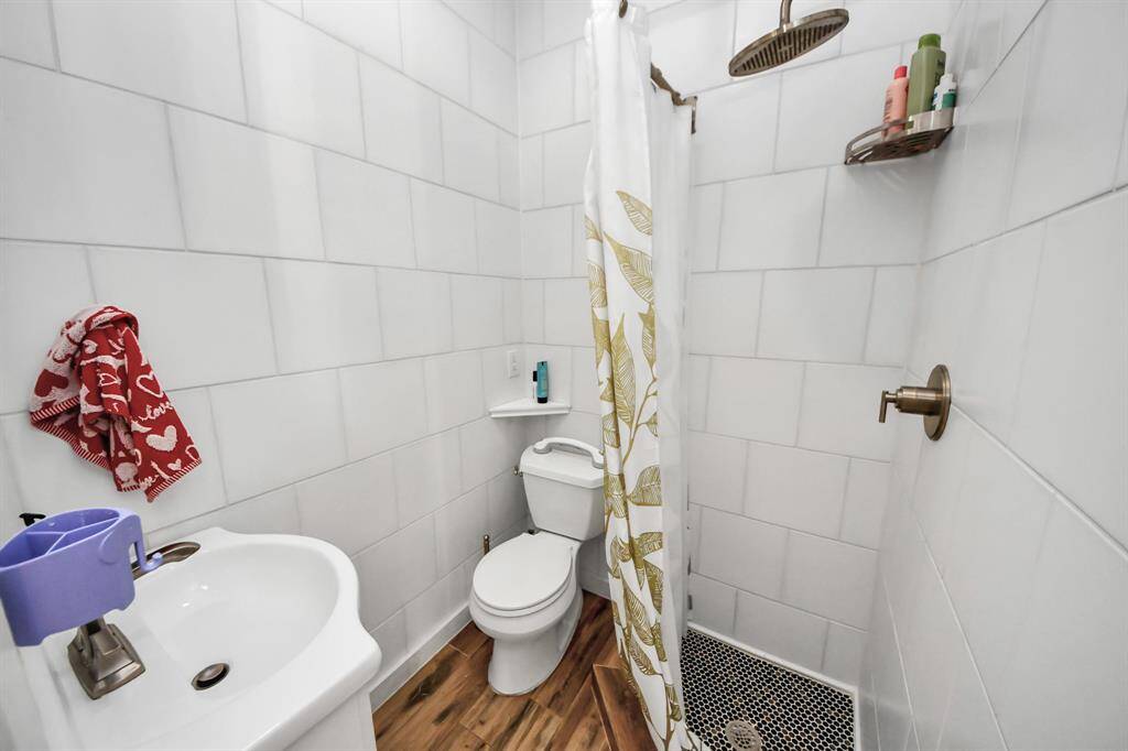 White subway tiles, a sleek walk-in shower with a rainfall showerhead.