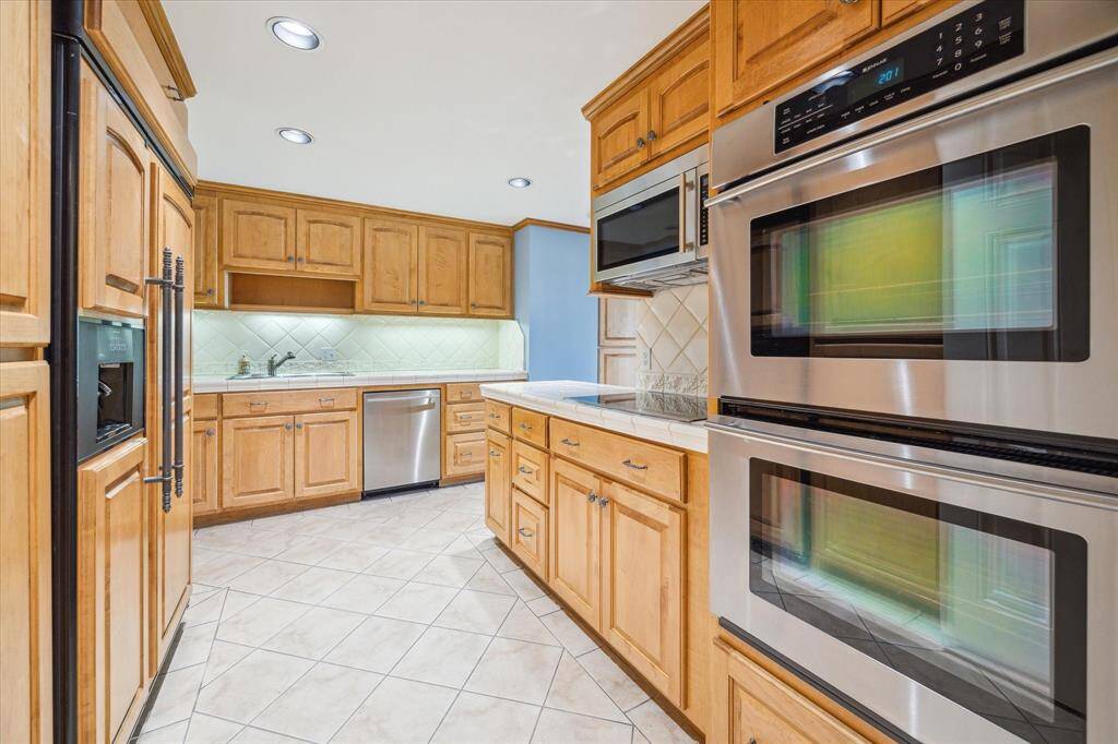 Kitchen with JenAir stainless appliances: double ovens, electric cooktop, micro-hood, & dishwasher. Paneled Refrigerator/Freezer included. Large Pantry space to the left not shown.