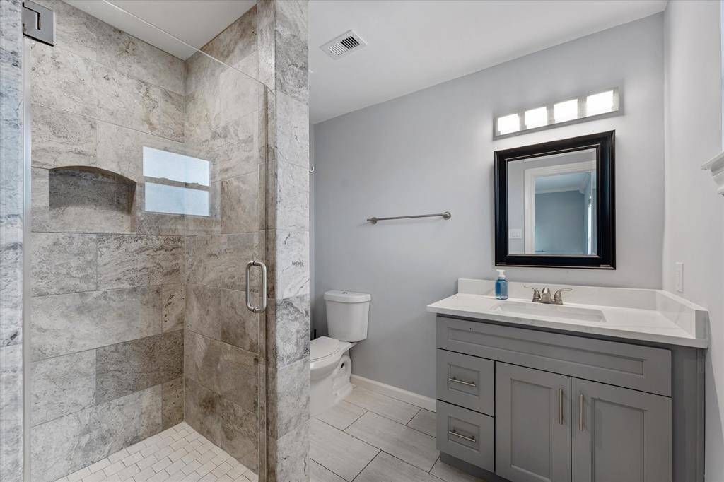 Here’s a look at the walk-in shower, built-in storage, and clean finishes in the en-suite bathroom.