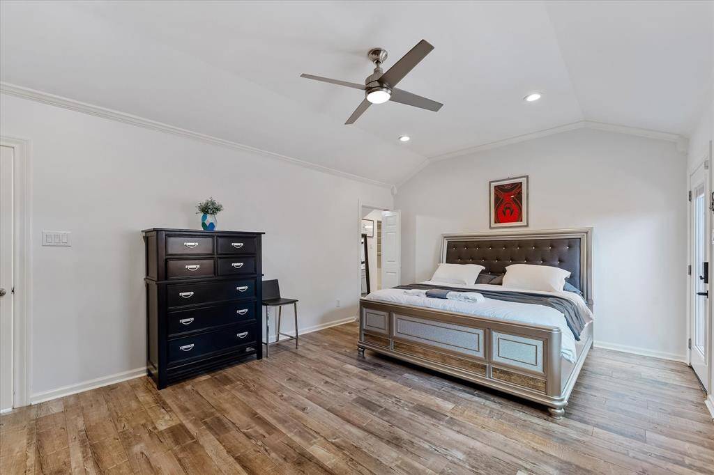 The primary bedroom features soaring ceilings, generous space, and direct access to a private patio — creating a quiet spot to relax and unwind.
