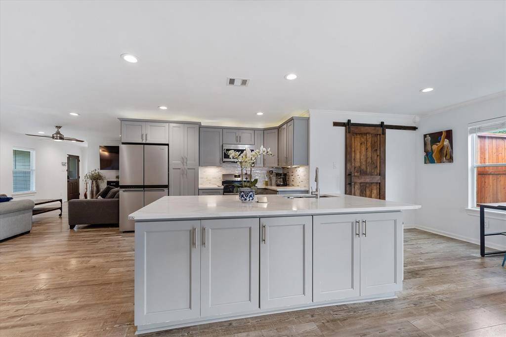 The large island offers generous storage and prep space, paired with a deep sink and ample cabinetry to keep everything organized and within reach.