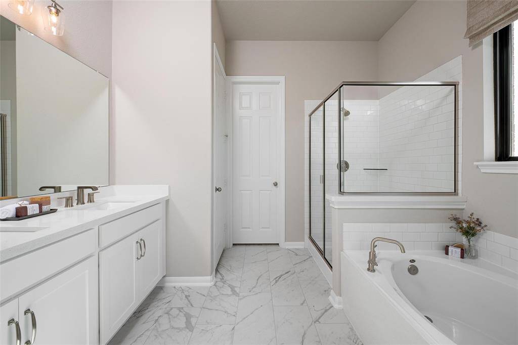 The en-suite bathroom offers a spa-like atmosphere with its elegant design, high end finishes, and tasteful lighting, creating a retreat within your own home.