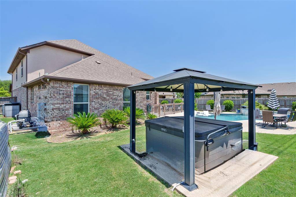 Enjoy a cozy evening soak in the hot tub, which features a covered pergola with built-in lighting for the perfect ambiance.
