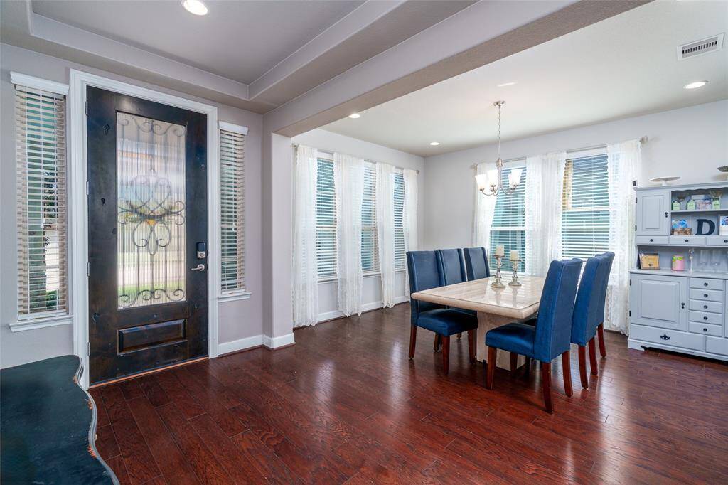 Upon entering the home, you’re welcomed by an elegant formal dining room filled with natural light, featuring multiple windows with privacy blinds, a stylish chandelier, and recessed lighting that adds a warm and inviting touch.