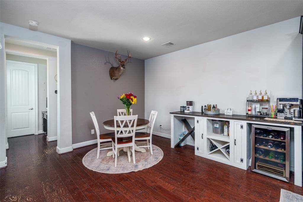 The breakfast nook, located just off the kitchen, features a stylish accent wall, engineered wood flooring, and recessed lighting—creating a cozy and modern space to enjoy your morning coffee.