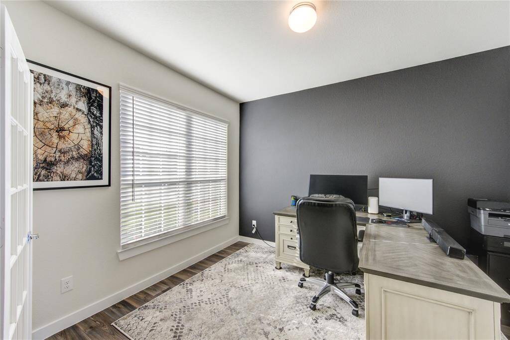Very spacious home office with large windows to look out to the front of the home.