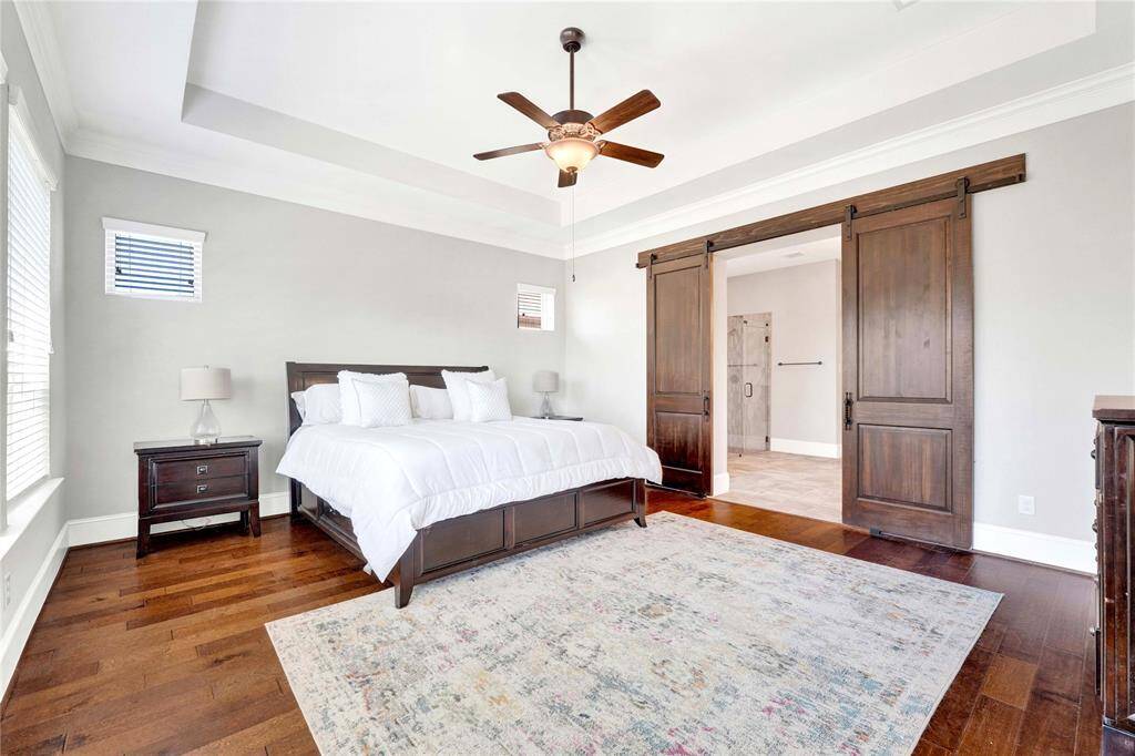 Sliding barn style doors lead you to primary bathroom