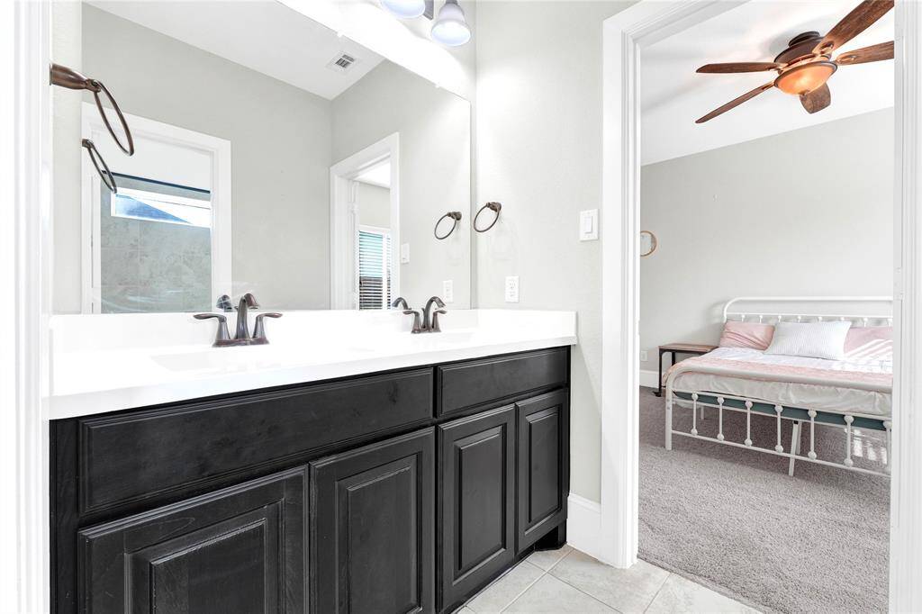 Dual sinks vanity area connects two large secondary bathrooms