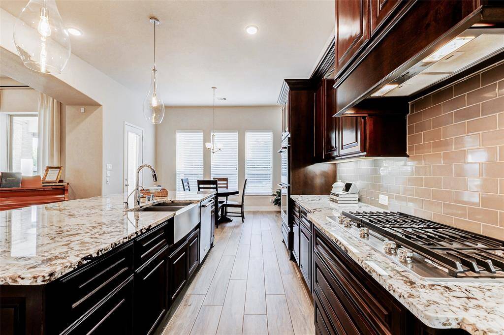 Additional highlights include asleek gas cooktopcomplemented by a vent hoodseamlessly integrated into therich wood cabinetry. Theseelegant cabinets not only elevatethe kitchen’s aesthetic but alsooffer abundant storage, perfectlybalancing style and functionality.