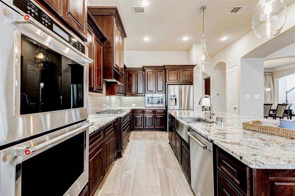 Equipped with stainless steeldouble ovens, a built-inmicrowave, and a stainless steelapron sink paired with adishwasher, this kitchen blendshigh-end appliances withthoughtful design for effortlessmeal preparation and cleanup.