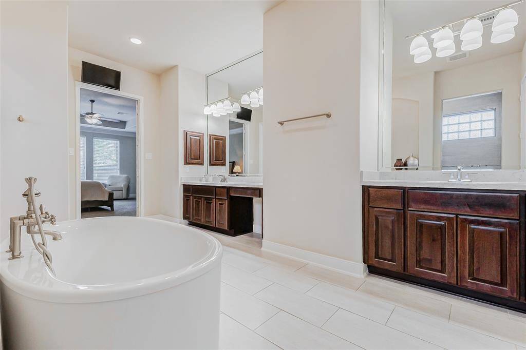 Featuring two separate vanities,each with its own sink andelegant nickel fixtures, theensuite is both functional andrefined. Sleek lighting fixturesare seamlessly integrated intothe mirrors, which extend fromthe vanities to the ceiling,enhancing the room’s bright andairy ambiance.