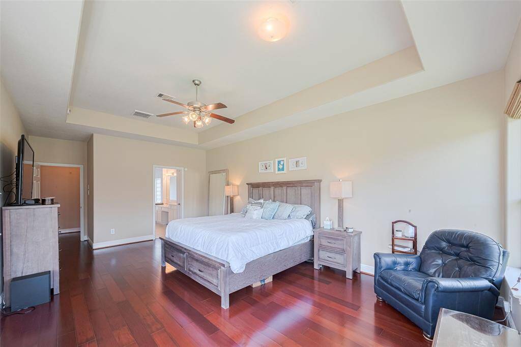 OVERSIZE Primary Bedroom with wood floors and Tray ceiling