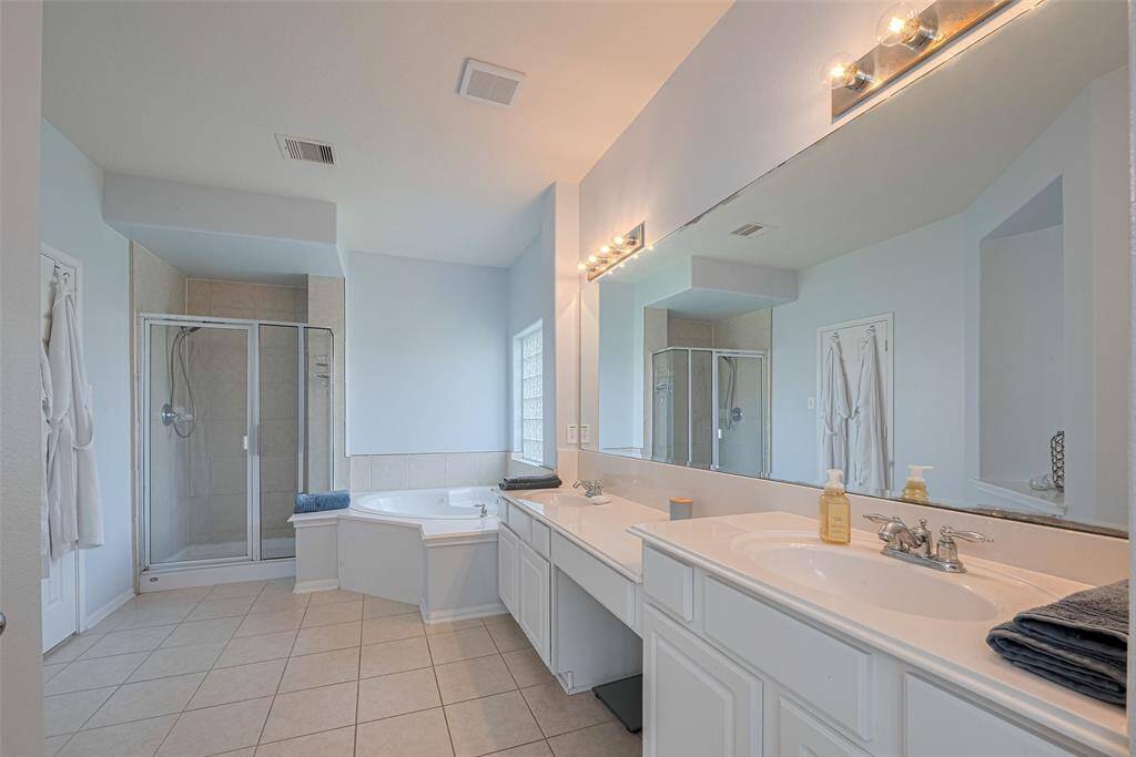 Primary Bathroom with double sinks and seated vanity area
