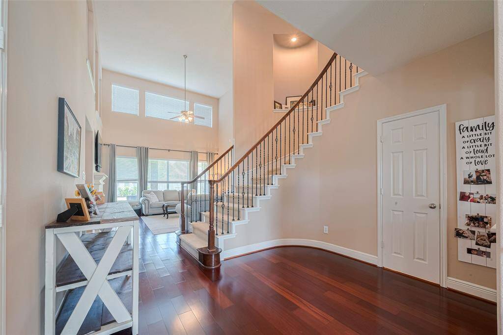 Up the elegant curved stairs to secondary bedrooms and game room