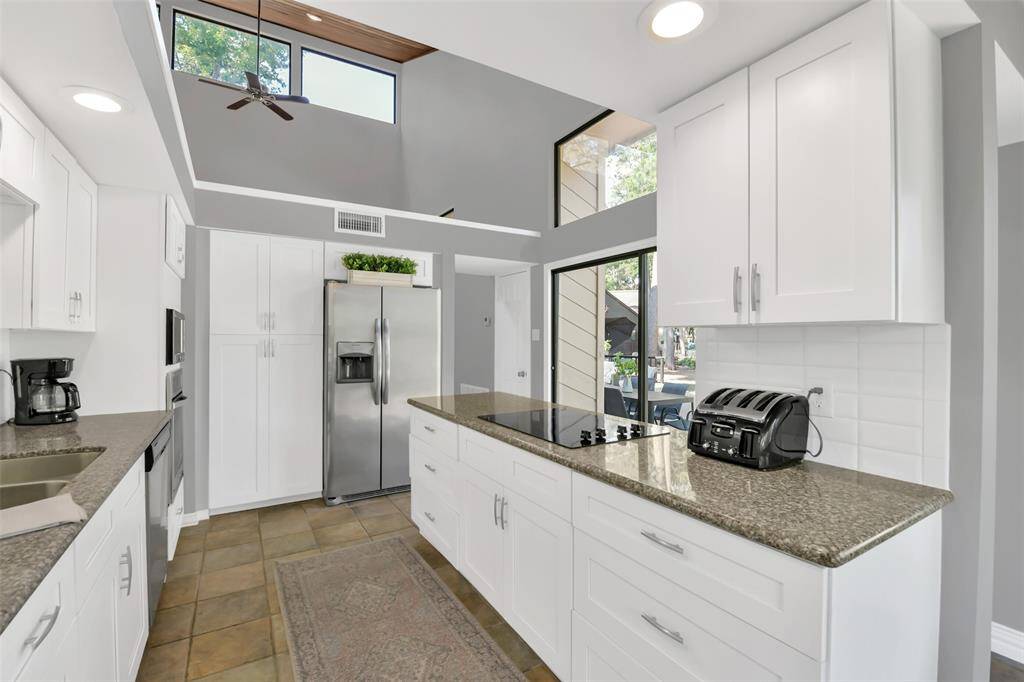 White kitchen cabinets and lots of storage - high ceilings are carried through the kitchen and breakfast room.