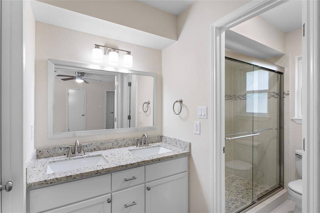 Primary bath w/ updated dual vanity and walk in shower.