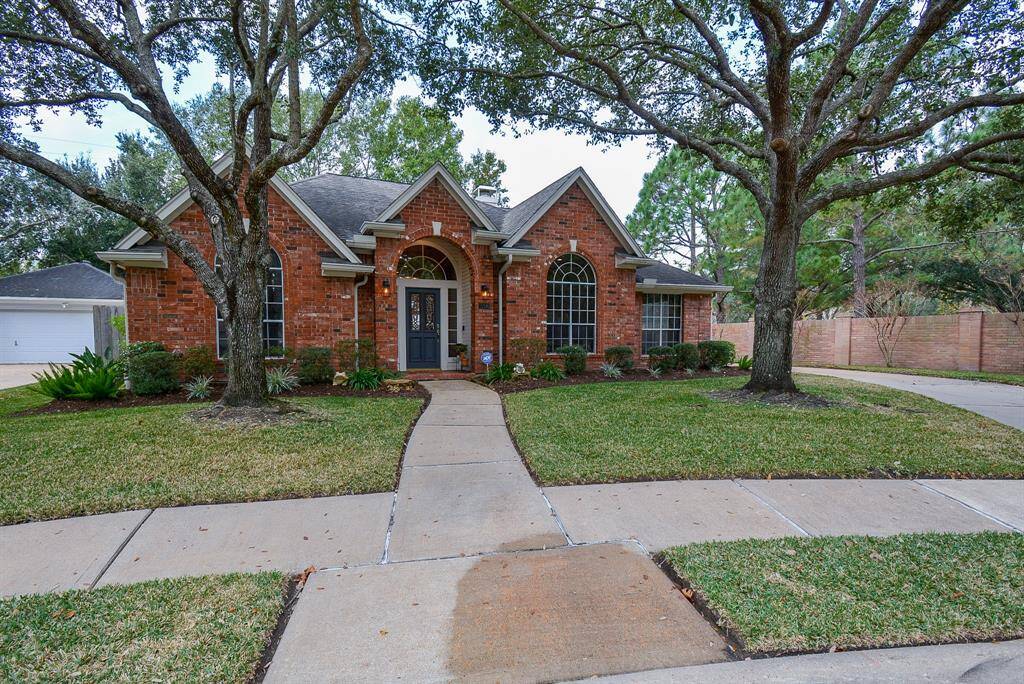 Carefully landscaped, the brick facade and mature trees bring great curb appeal. Park is on the right side, behind brick wall.