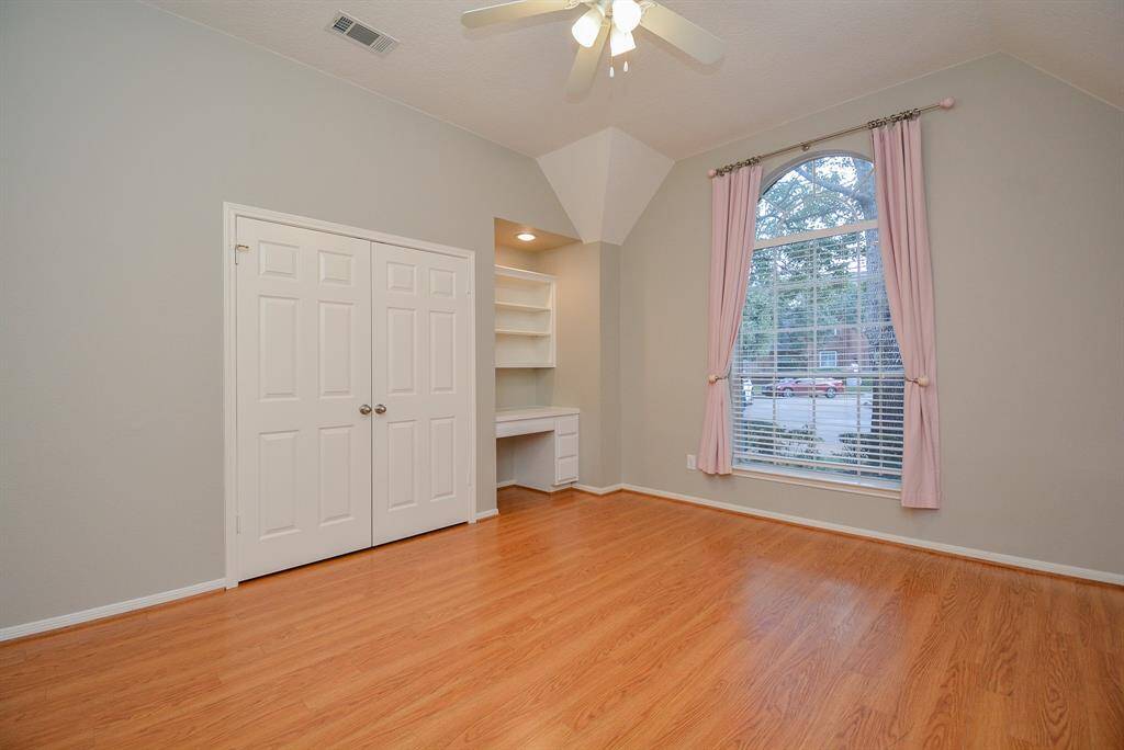 Secondary bedroom with large window features built in desk and shelves. Pottery barn blackout panels.
