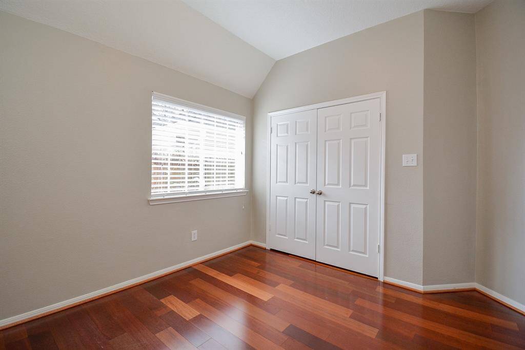 Secondary bedroom next to primary bedroom features beautiful Brazilian cherry wood floors.  This bedroom faces south and has plenty of light throughout the day