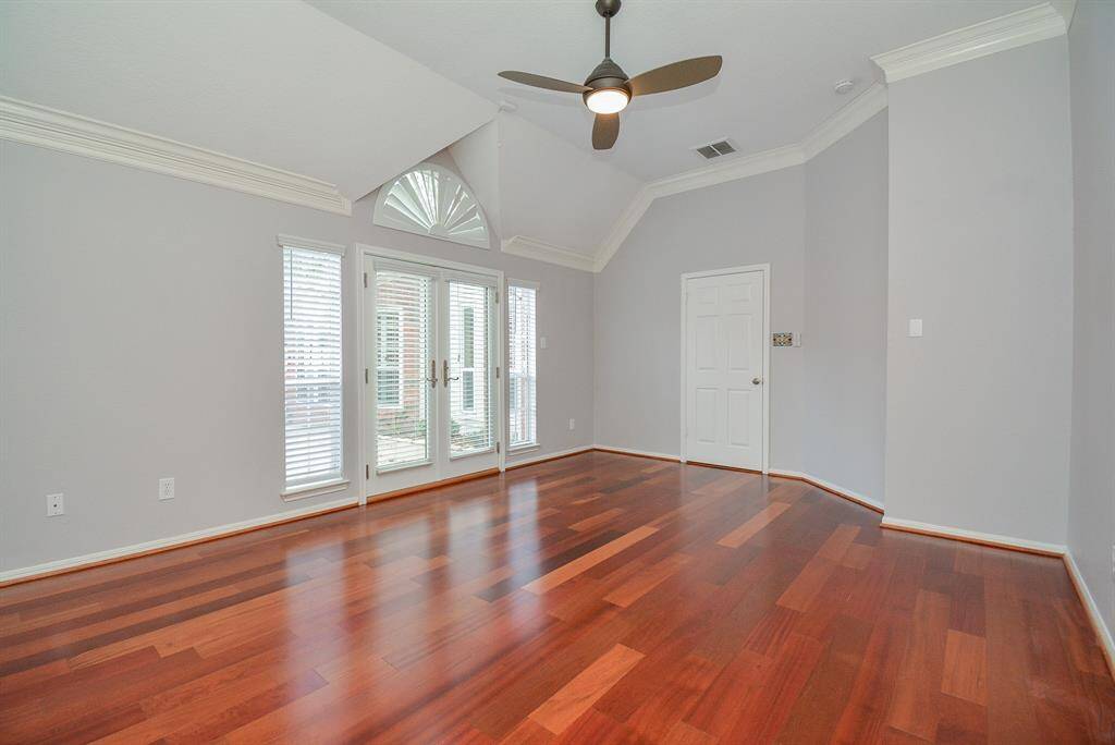 Ample primary bedroom features beautiful Brazilian cherry wood floors has access to the patio through French doors.