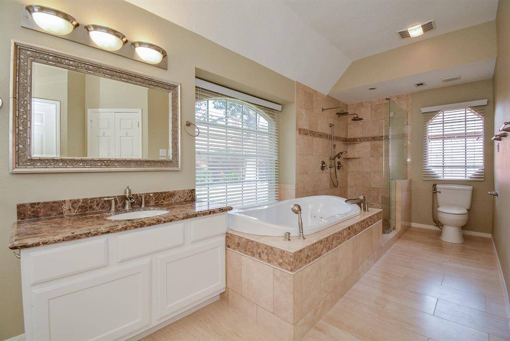 Large primary bathroom has double sinks, jetted oversized bathtub and an XL double shower.