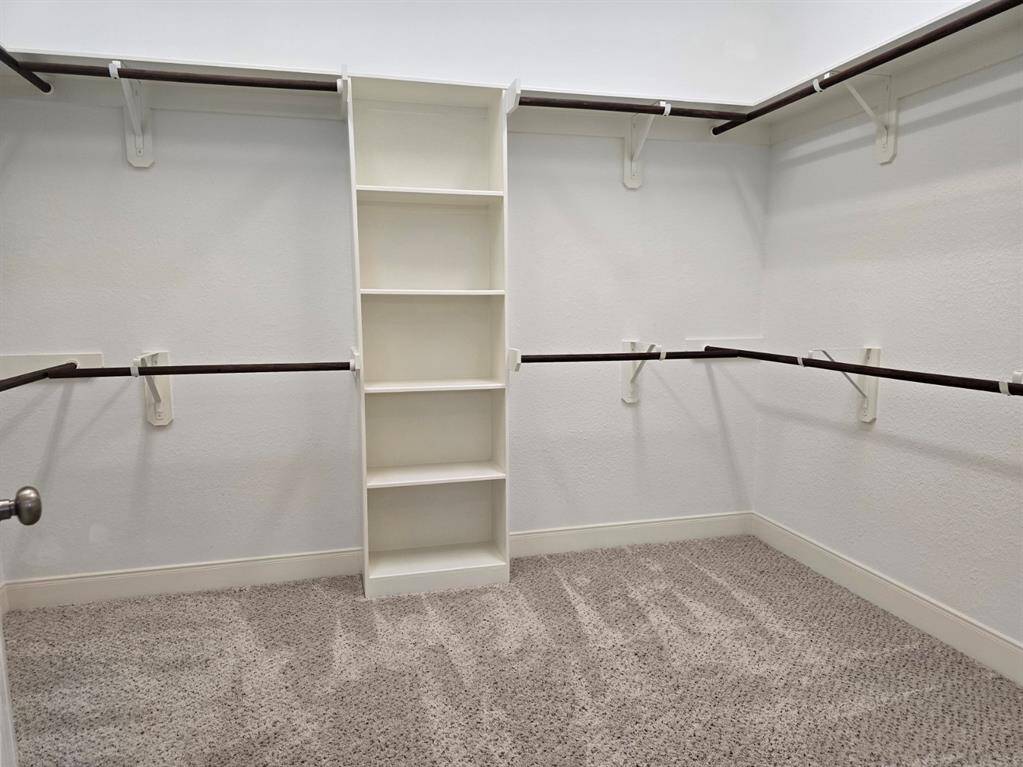 Step into the grand walk-in closet connected to the primary bathroom, providing loads of space.
