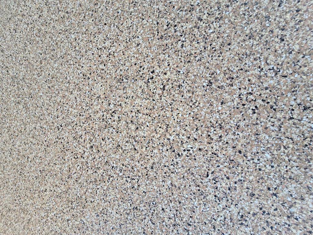 The covered patio is finished with a robust polyurea flooring cover, designed for years of outdoor enjoyment.