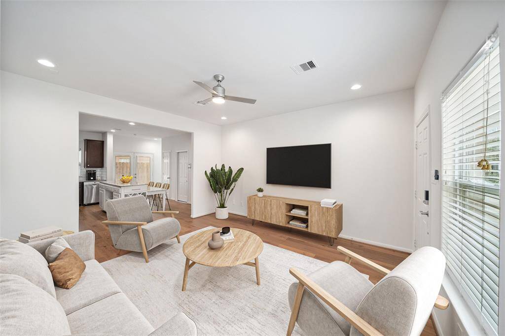 The view of the living room showcases the seamless flow from the living area to the kitchen. *virtually staged