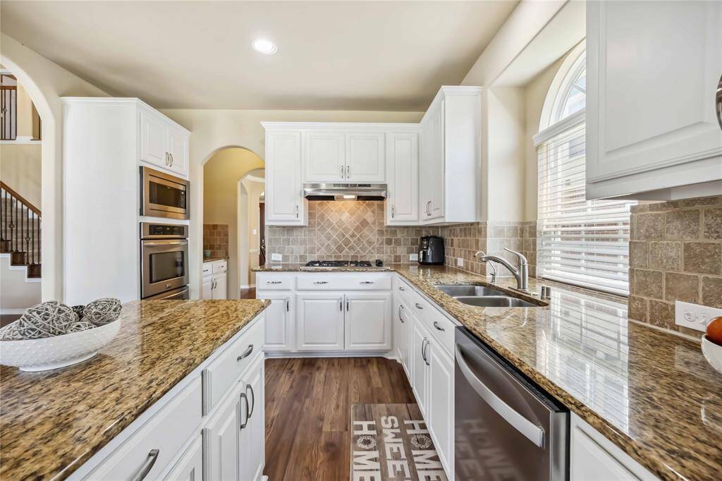 SS appliances and updated white cabinets with gorgeous silver hardware accents throughout kitchen.