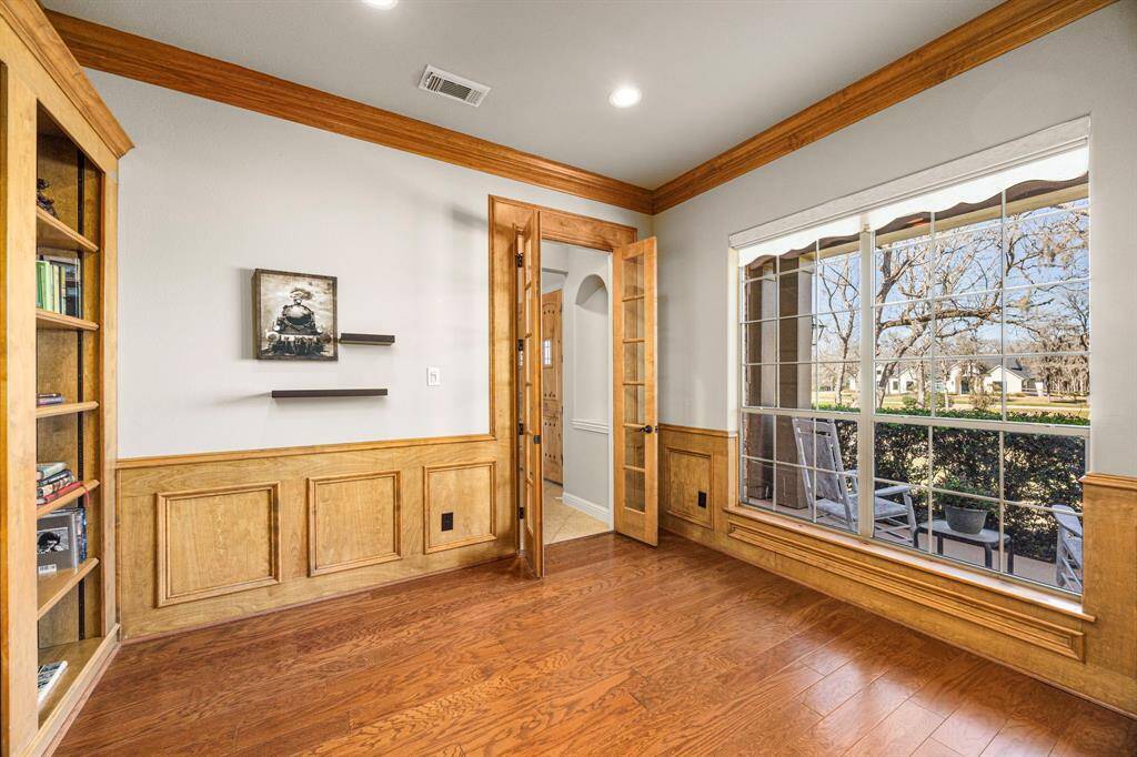 The Home Office, conveniently located just off the Foyer, is accessed through elegant double glass-pane French doors. A large bay window fills the space with natural light, creating a warm and inviting atmosphere. Crown molding and wainscoting add a sophisticated touch, making this the perfect space for work or study.