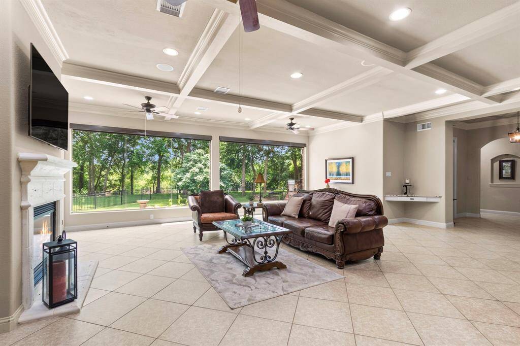 The Family Room is breathtaking, featuring expansive double butted windows that offer unobstructed views of the stunning backyard, pool and spa, and the serene Brazos River. This spacious area is designed for both elegance and comfort, boasting 18x18 tile floors, a beautifully detailed coffered ceiling, and three ceiling fans to enhance airflow and style.