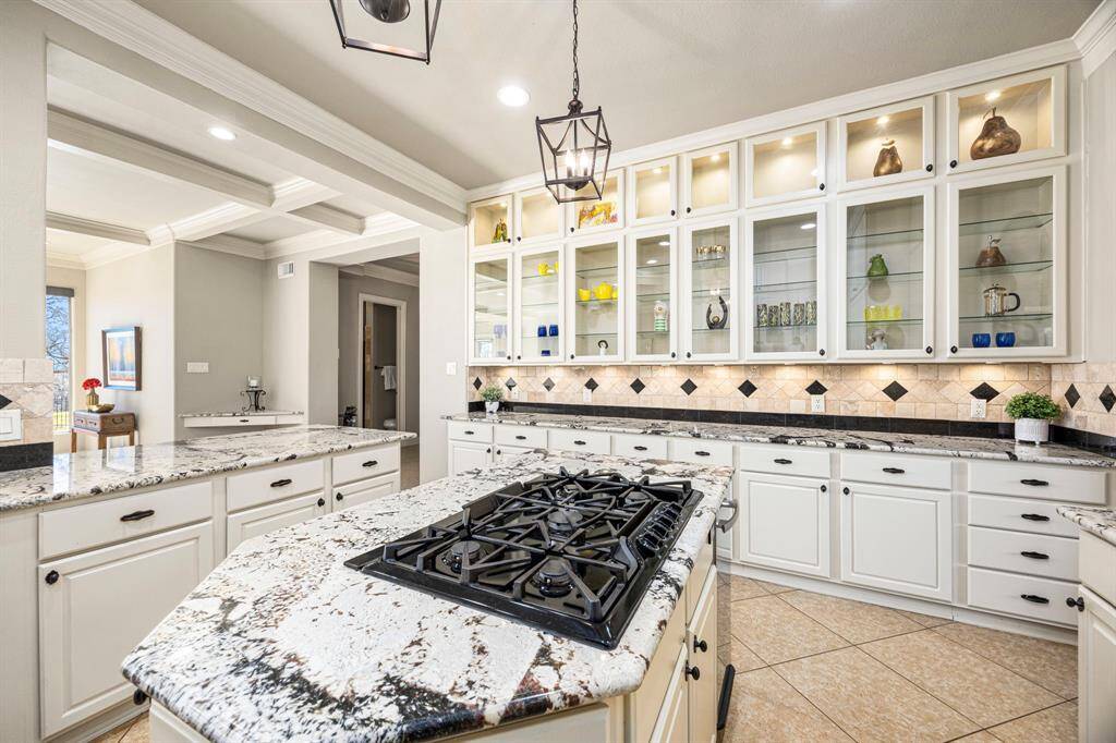 The Kitchen also features beautifully crafted cabinets with glass fronts, perfect for showcasing fine dishware or décor. A spacious granite countertop offers ample workspace and doubles as a convenient buffet area, making it perfect for entertaining guests.