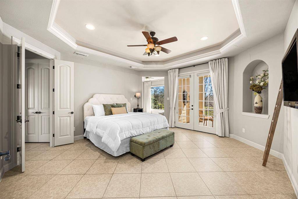 The Primary Suite is grand, featuring 18x18 tile floors, a 10-foot pop-up ceiling with elegant detailing, and an art niche for added character. A designer ceiling fan enhances the space, while gorgeous glass-paned doors lead to your own private covered patio—perfect for relaxing and taking in the breathtaking views.