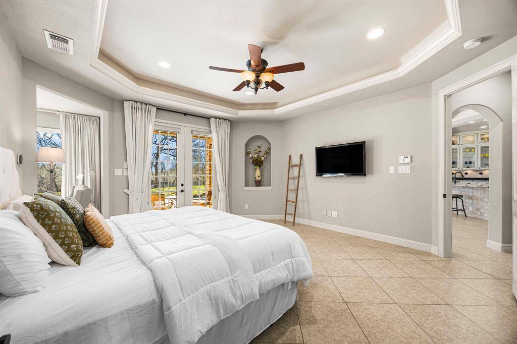 The room offers ample wall space, providing flexibility for furniture placement, and is situated at the back of the house for added privacy and tranquility. Warm color tones enhance the inviting and relaxing ambiance.