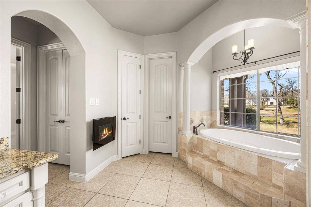 The Primary Bath features two large walk-in closets, each equipped with automatic light turn-off switches built into the door hinges for added convenience. The closets also offer plenty of built-ins for optimal organization, while an electric fireplace heater enhances the space, providing warmth and a cozy ambiance.