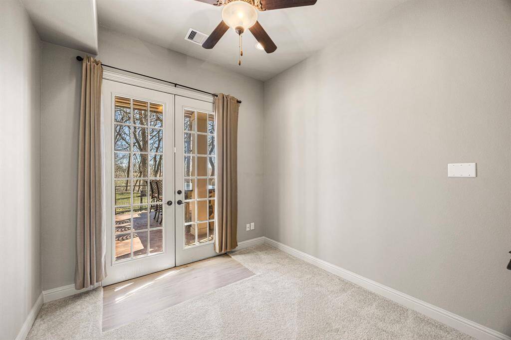 The Flex Room in the Guest Suite is located downstairs and features double glass-pane doors with elegant curtains, offering privacy and versatility. It also includes a spacious walk-in closet, making it ideal for use as an additional Bedroom, Home office, Home Gym or private retreat.