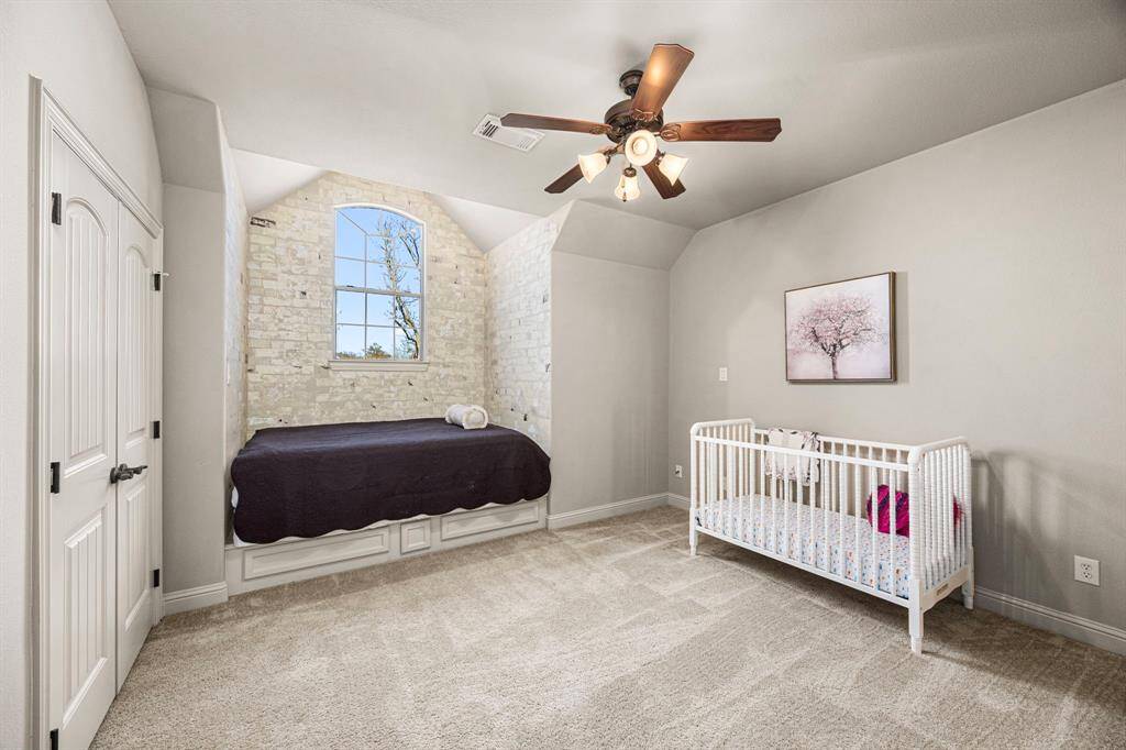 This Bedroom is located at the front of the house and features a charming painted brick accent wall surrounding the built-in platform bed area, with a large window above that fills the space with natural light. A double-door closet provides ample storage, and the room offers direct access to a Jack and Jill Bath for added convenience.