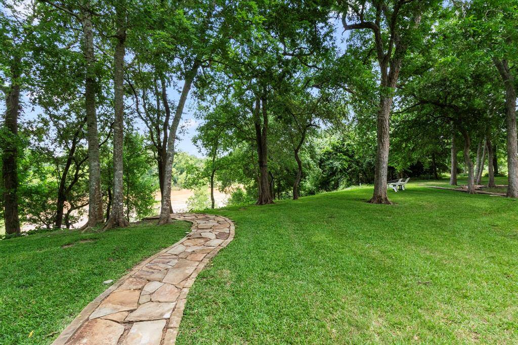 A beautifully crafted flagstone trail leads to the Brazos River, offering stunning views along the way.