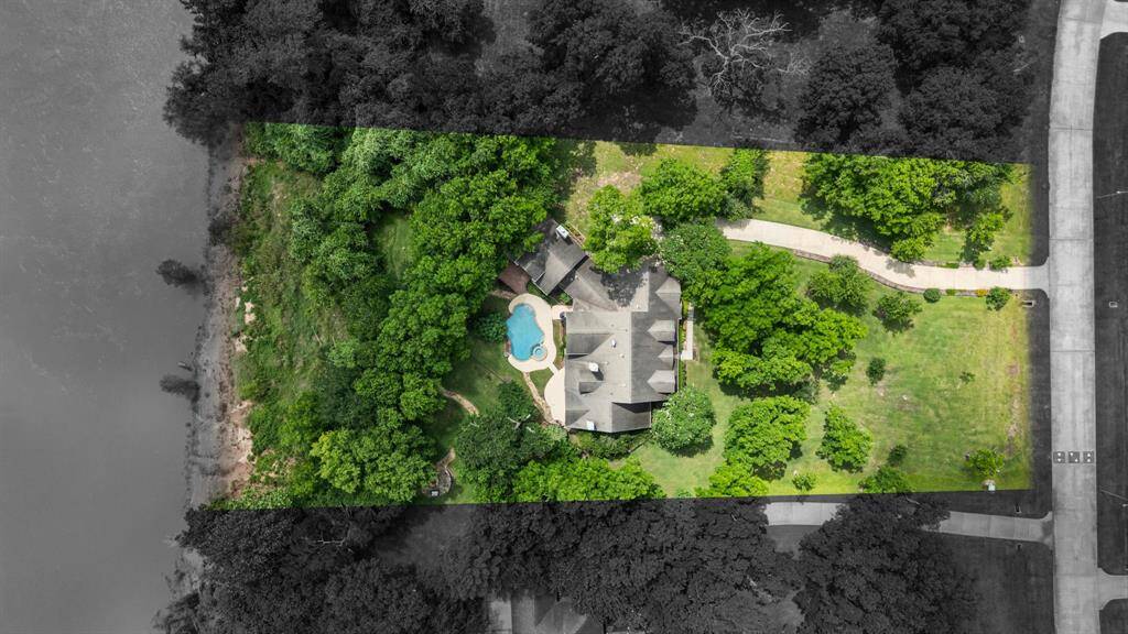 One more bird’s-eye view provides a broader perspective, with approximate property lines shown to help visualize the layout and boundaries of the land. The surrounding area has been shaded darker to help emphasize the property itself.