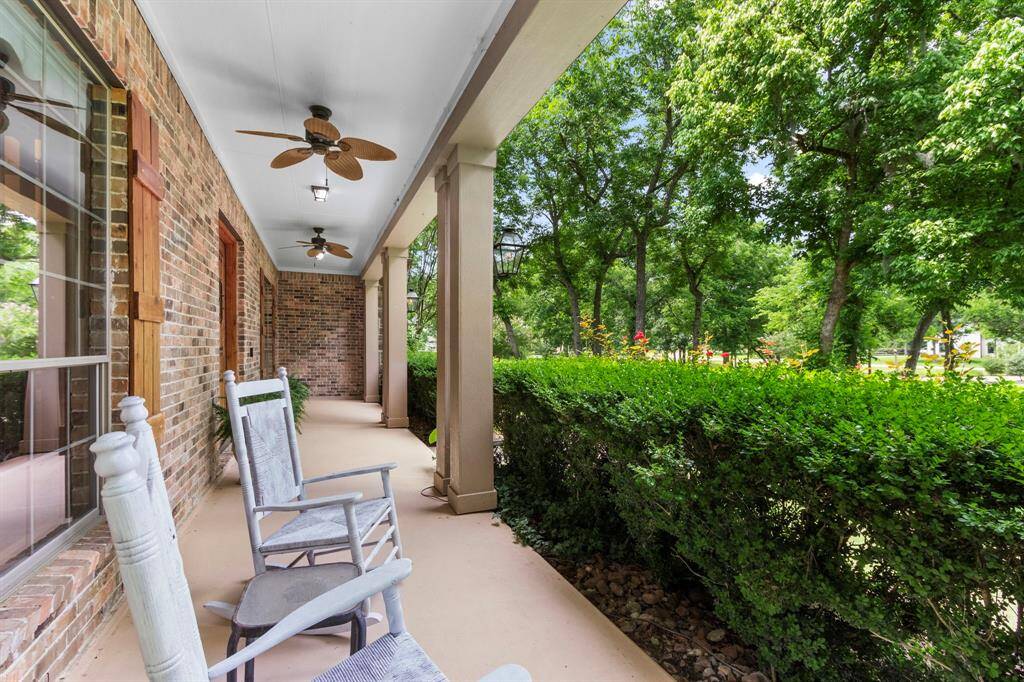 As you approach the front entrance, you're greeted by lush landscaping framed by a pebble stone border. The inviting covered Front Porch spans the length of the home and features freshly painted concrete flooring, elegant pillars, two ceiling fans, and three ceiling lights—ensuring comfort in any season. A charming set of gas coach lights and two tranquil water features add warmth and character to the space. From this vantage point, you can enjoy sweeping views of the expansive front yard.