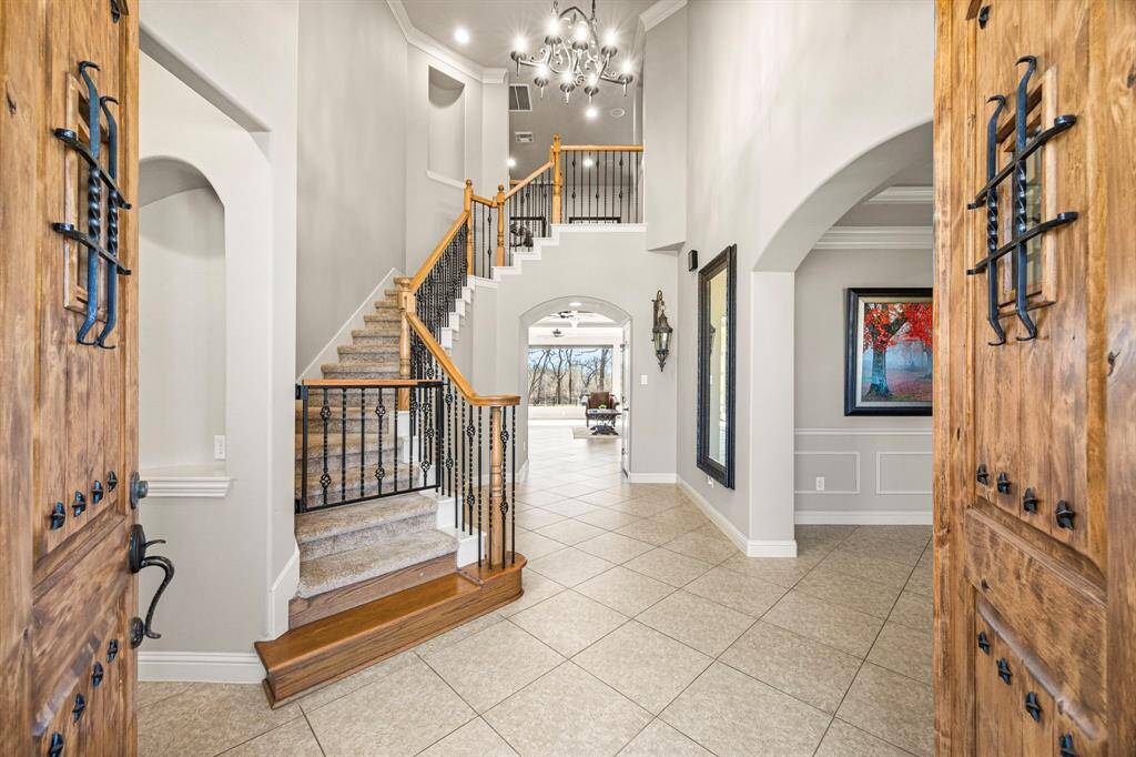 As your guests enter the home, they are welcomed by elegant 18x18 designer tile flooring, a stunning wrought iron staircase, and soaring 20-foot ceilings, all complemented by breathtaking views that stretch as far as the eye can see.