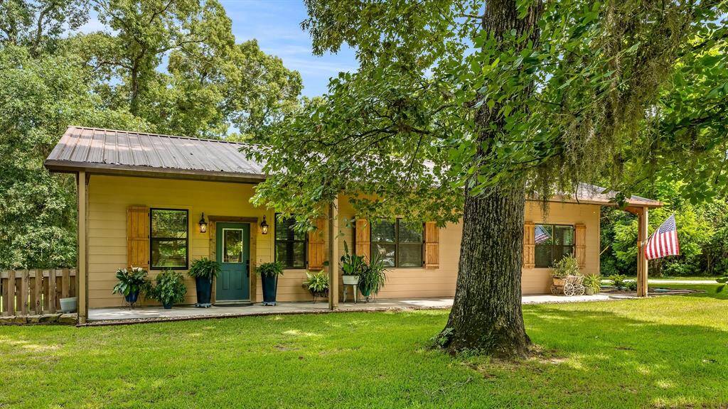 Enjoy the welcoming porch, nestled among mature trees, featuring a quaint exterior with a metal roof and a serene, natural setting. This home has its own well, aerobic septic system and generator. It is completely handicapped accessible from the entrance at the front door and throughout the home. It is built with steel framing, on demand hot water and spray foam insulation.