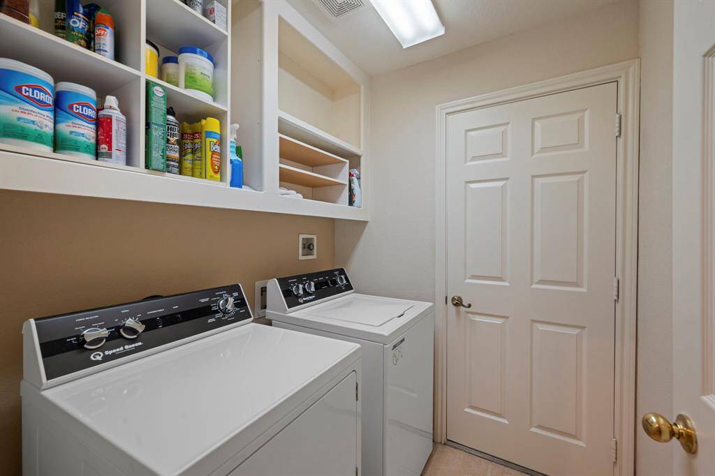 Bright and functional laundry room with electric and gas connections for your own washer & dryer with overhead storage. Includes a privacy door and door leading to the garage.